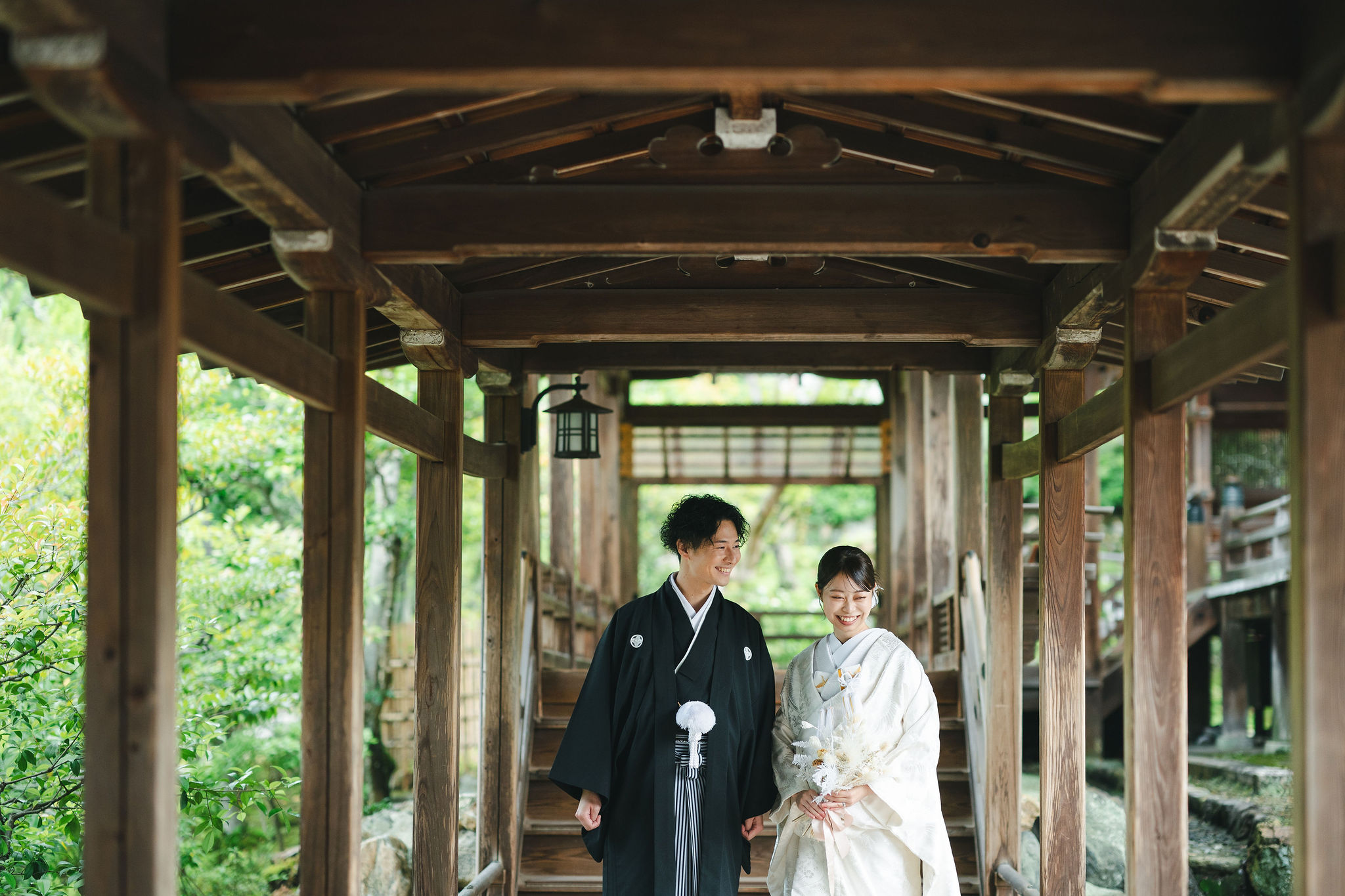 京都の仁和寺。御所庭園内の廊下を進む新郎新婦