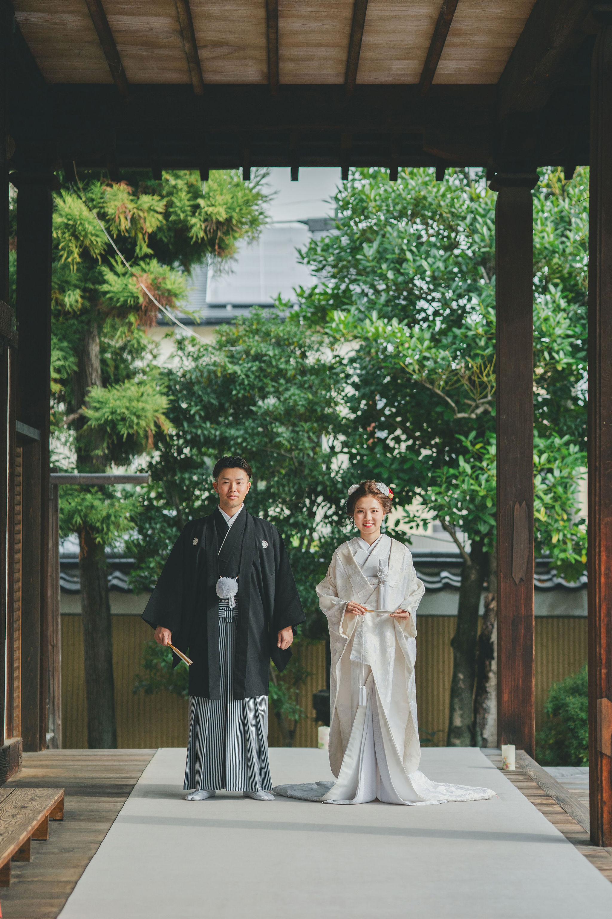 妙顕寺の縁側で立つ和装姿の新郎新婦