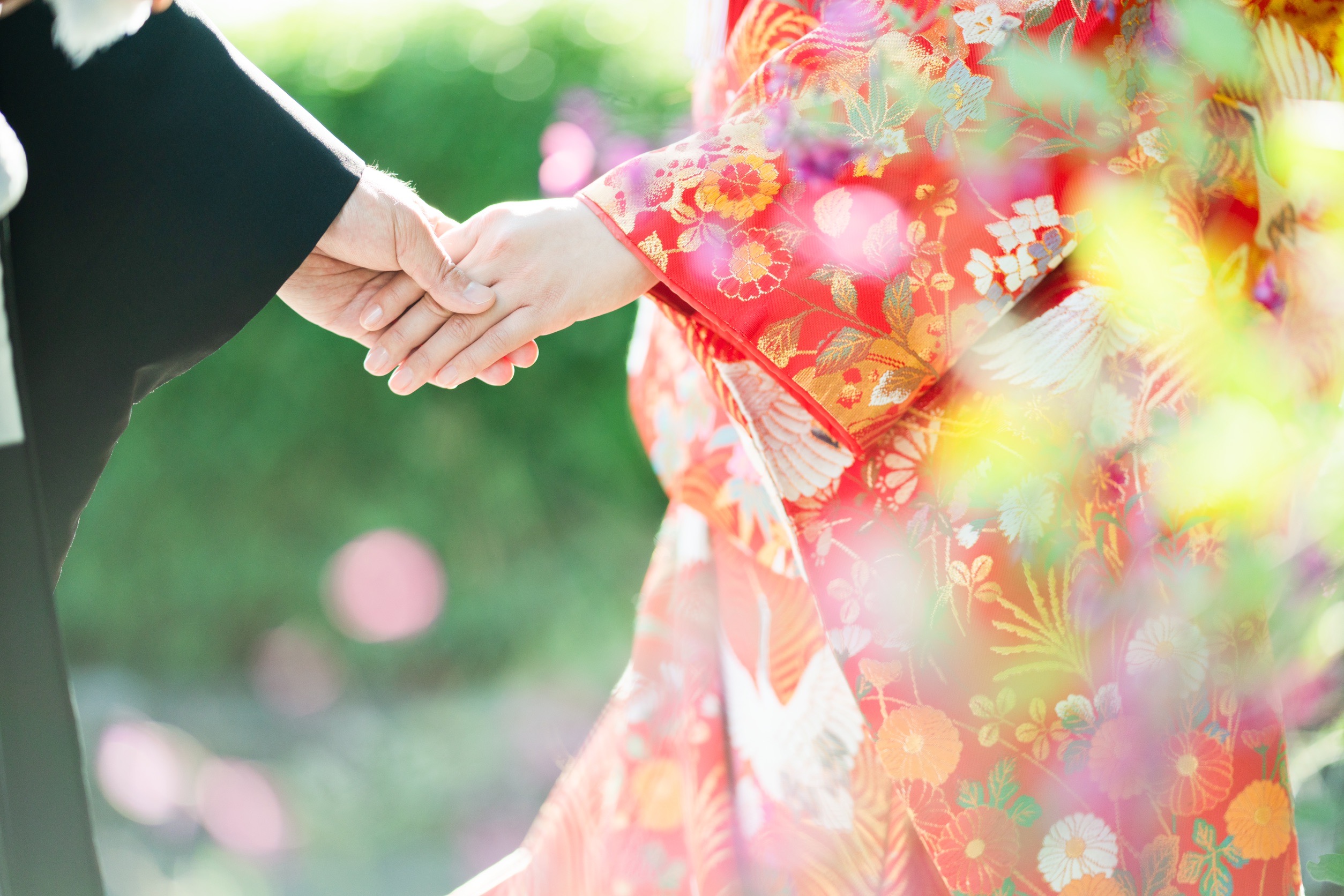 朱色の色打掛と黒紋付を羽織る新郎新婦様の手元