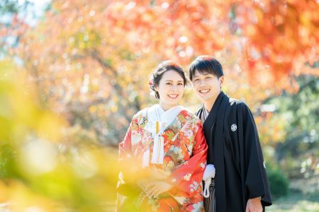 紅葉の中、笑顔の花嫁花婿さん