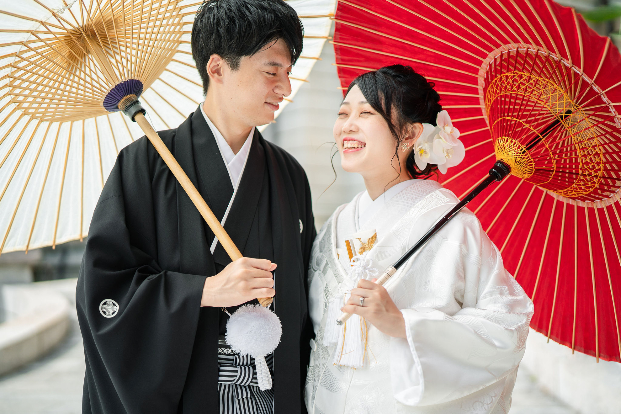 笑顔で和傘をもった新郎新婦