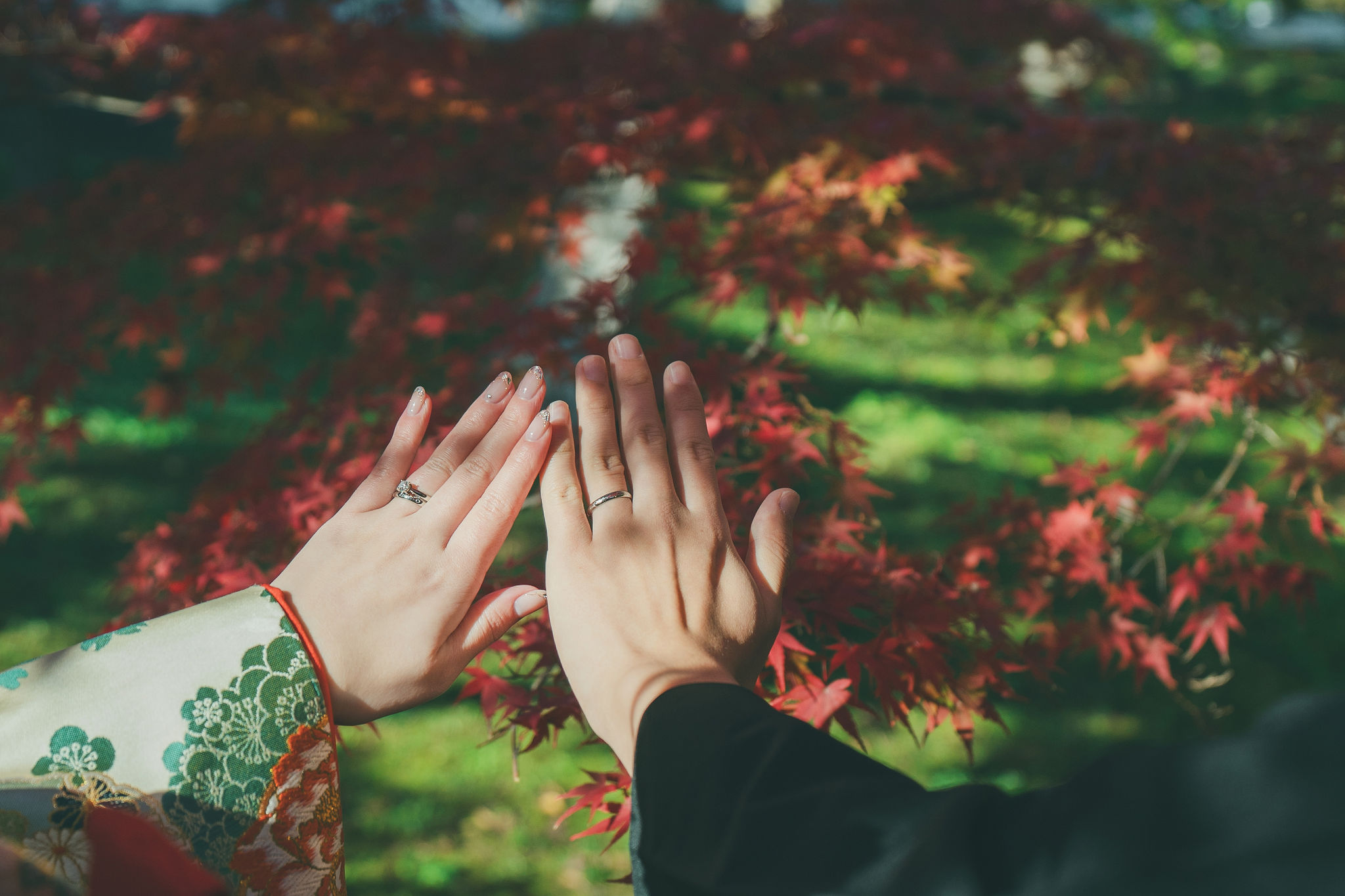 智積院の紅葉を背景に結婚指輪を見せる新郎新婦の手元フォトカット