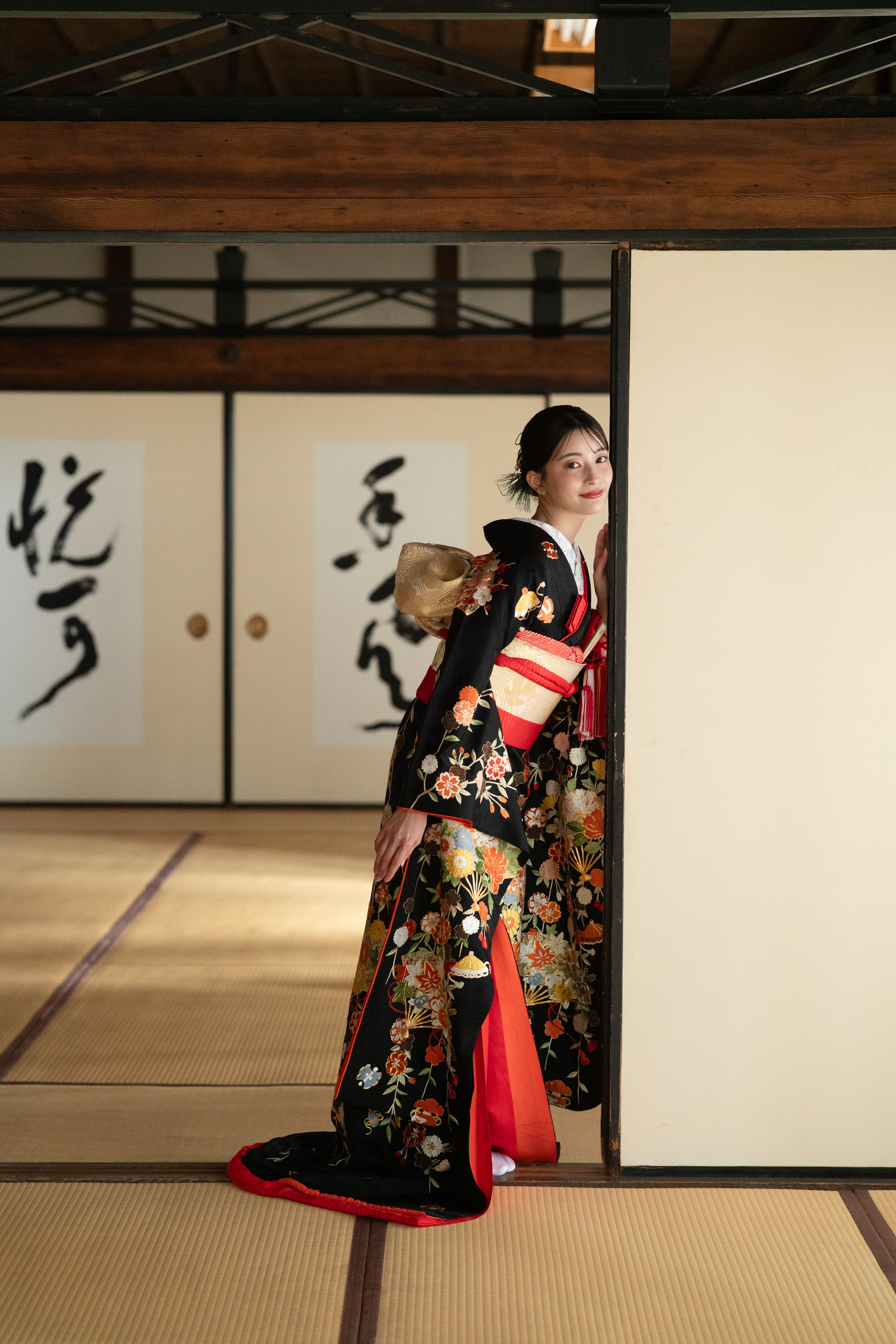 京都の寺院で黒の引き振袖を着た花嫁の前撮り、和室で振り返る姿