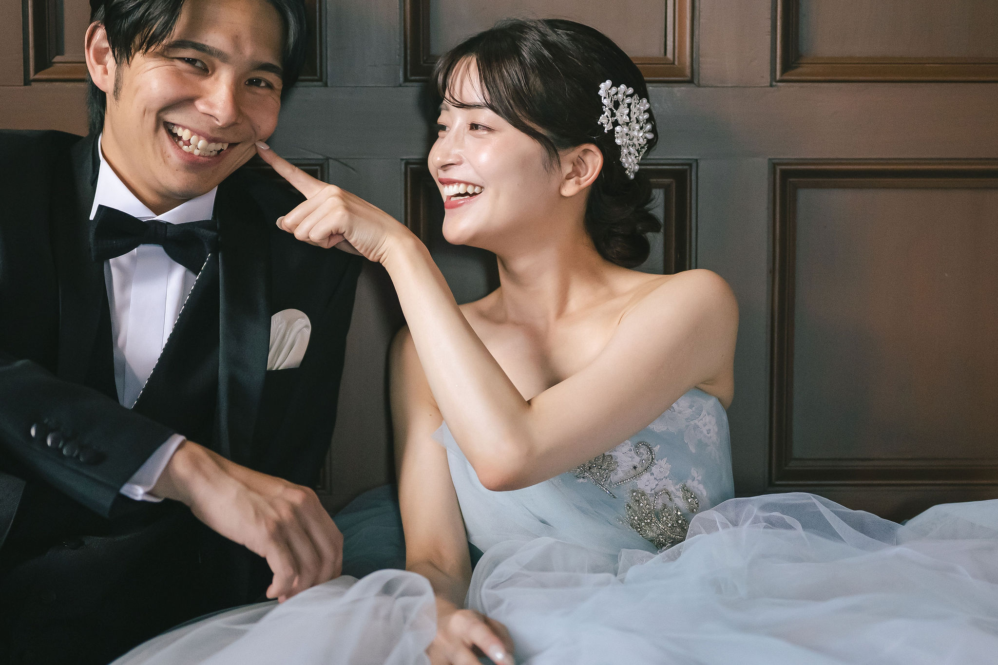 笑顔で見つめ合うウェディングドレス姿の新婦と新郎