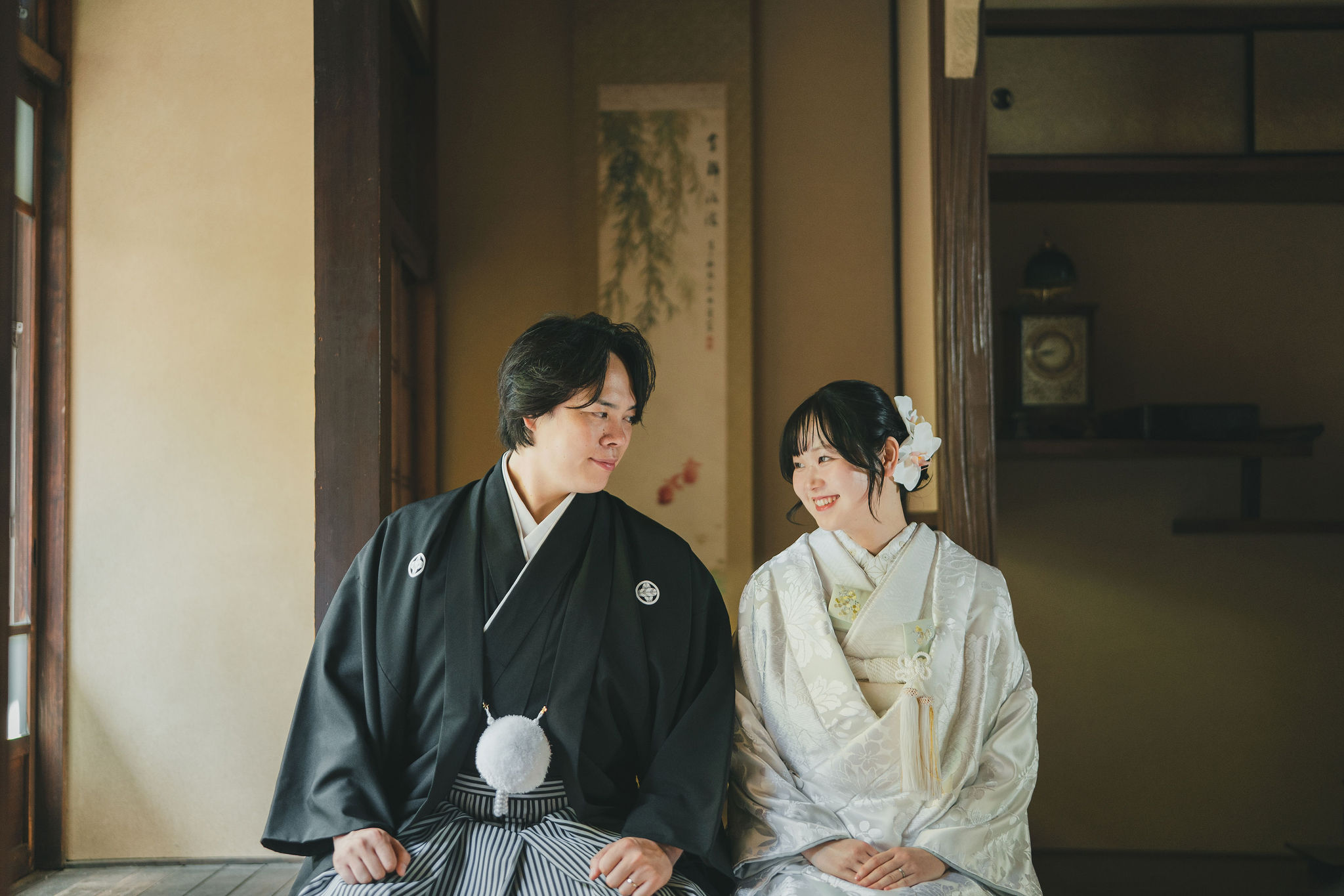 京町家の畳の座敷で、白無垢の花嫁と黒紋付袴の新郎が並ぶ和装前撮り写真